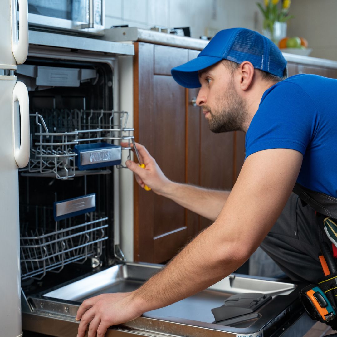 Technician repairing a dishwasher
