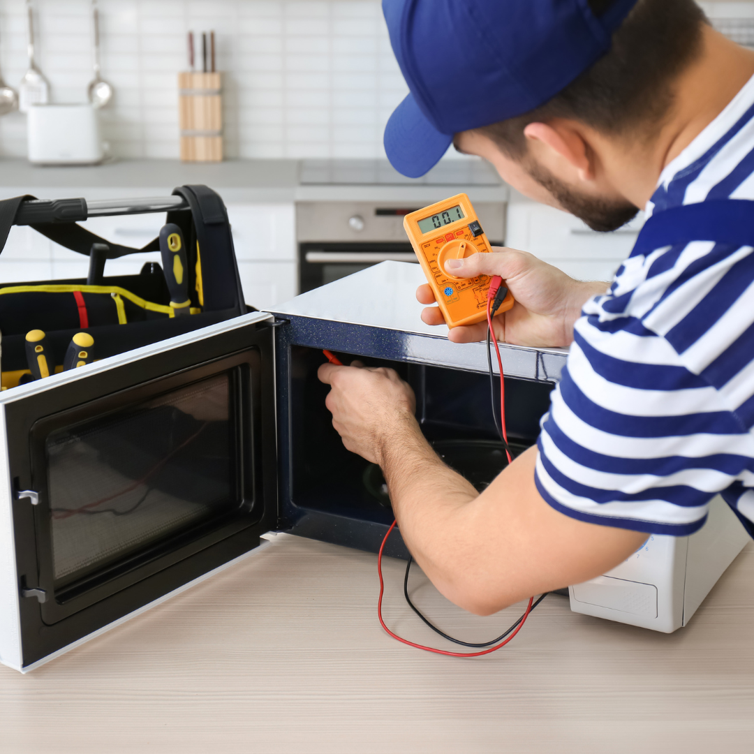 Technician testing a microwave with a meter